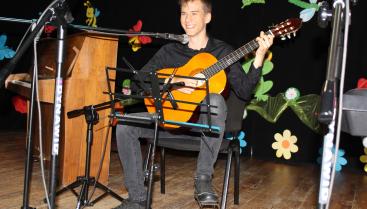 Uczeń ogniska śpiewający i grający na gitarze-zdjęcie.
